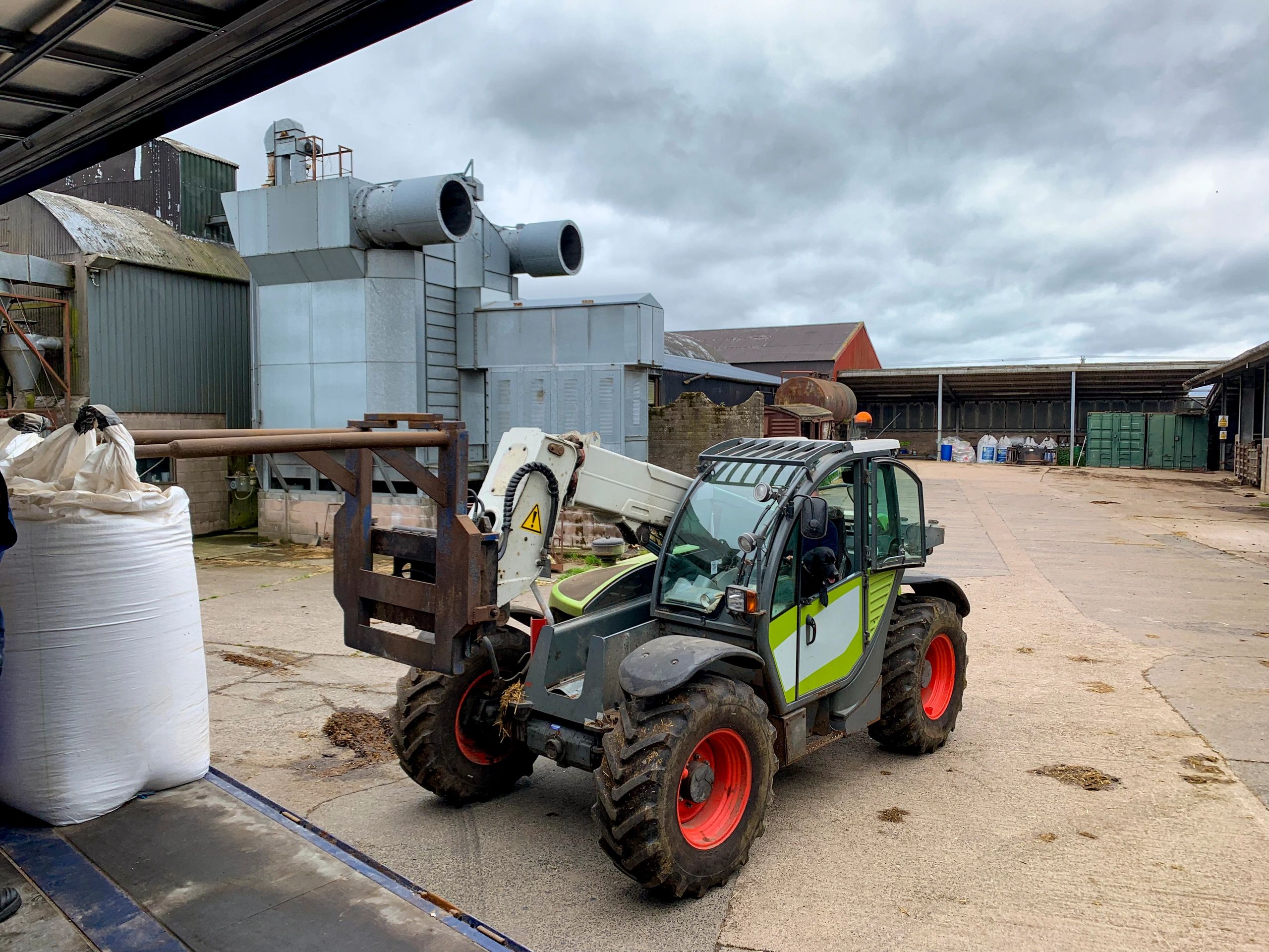 Open deck trailer loading equipment in a yard