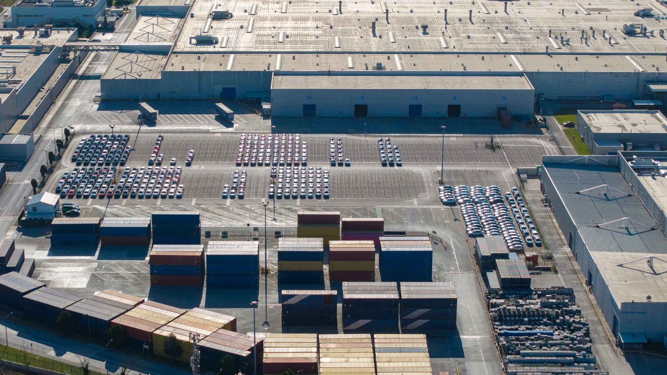 Large industrial shipping yard with vehicles and freight activity